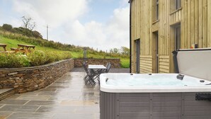 A patio area with a hot tub, stone wall, and outdoor seating. - 6 bedroom accommodation in Wolsingham, near Stanhope (Wolsingham, near Stanhope)