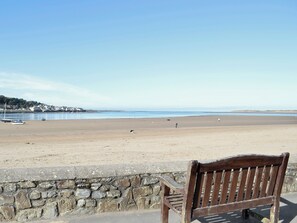 A bench overlooking a beach with a stone wall in the foreground. - 4 bedroom accommodation in Ford, near Bideford (Ford, near Bideford)