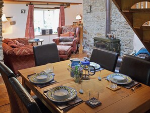 A dining area with a wooden table set for four, surrounded by leather chairs.