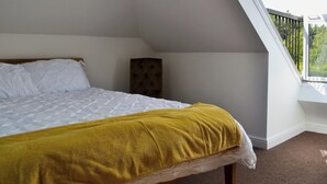 A bedroom with a bed, a window, and a view of greenery outside. - 3 bedroom accommodation in Farnham (Farnham)