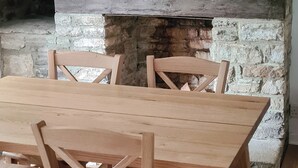 A rustic stone wall with a wooden table and chairs. - 3 bedroom accommodation in Harmans Cross, near Swanage (Harmans Cross, near Swanage)