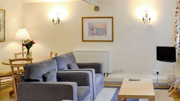 A living room with a sofa set, a coffee table, a TV, and a framed picture on the wall. - 2 bedroom accommodation in St Kew, near Port Isaac (St Kew, near Port Isaac)