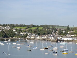 Un port où l’on voit de nombreux bateaux, avec des maisons en arrière-plan.