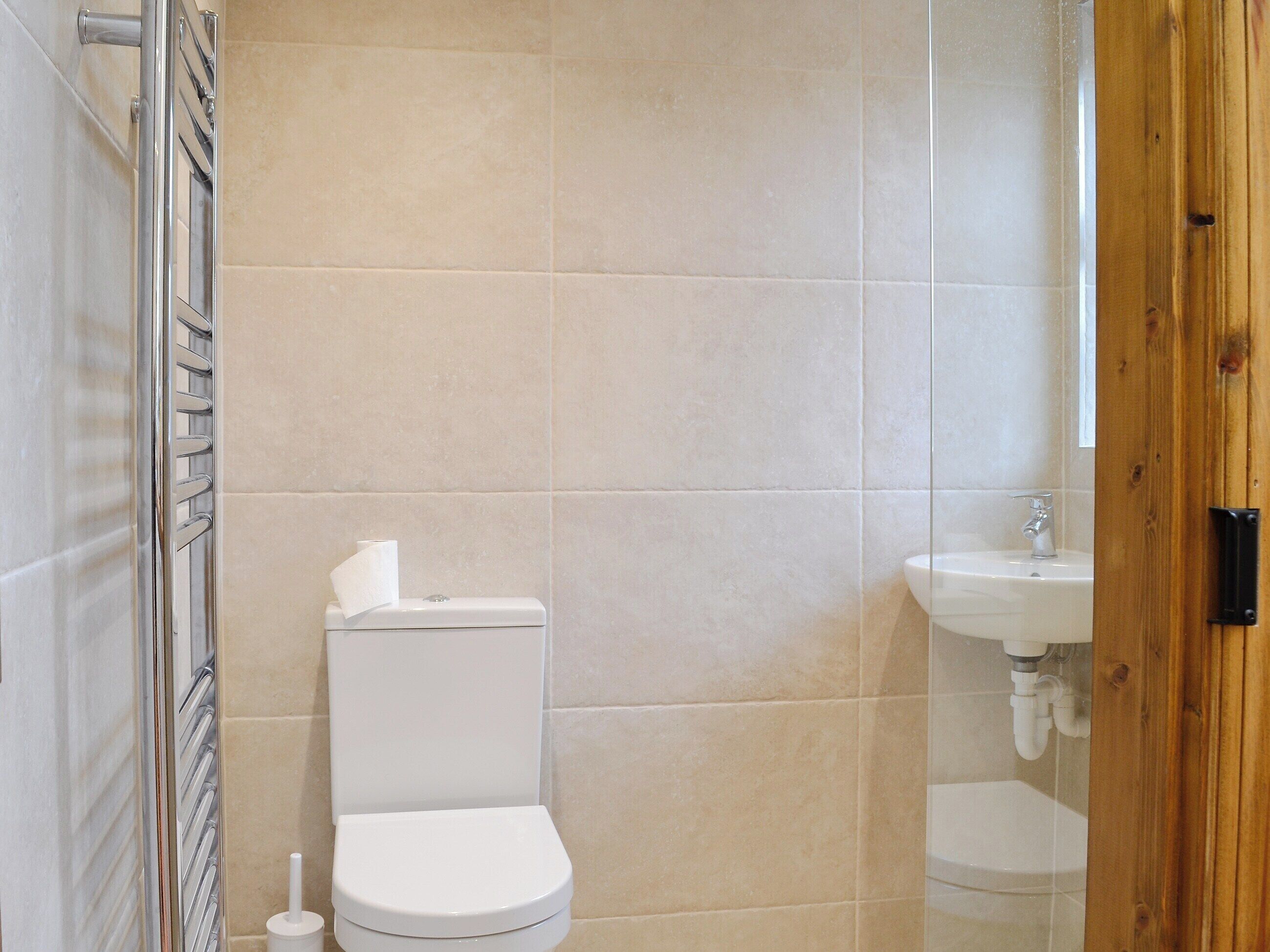 Ein Badezimmer mit Toilette, Waschbecken und Duschbereich.
