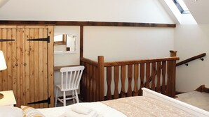 A bedroom with a wooden bed, a chair, a desk, and a skylight. - 3 bedroom accommodation in Tickton, near Beverley (Tickton, near Beverley)