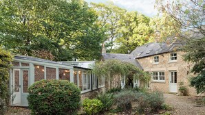 A stone house with a conservatory, a deer head mounted on the wall, and a garden with a lawn and leaf-covered ground. - 3 bedroom accommodation in Riding Mill, near Corbridge (Riding Mill, near Corbridge)