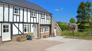 A two-story Tudor-style building with a large driveway and a fenced garden area. - 4 bedroom accommodation in Ashperton, near Ledbury (Ashperton, near Ledbury)