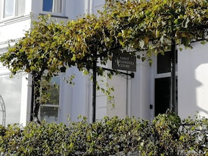 A building with a sign reading 'SAINT CATHERINES COURT' and a vine-covered entrance.