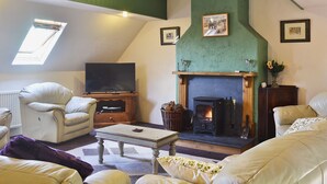 A cozy living room with a fireplace, a television, and comfortable seating.