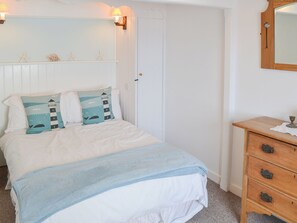 A bedroom with a bed, a nightstand, and a dresser. - Beach Corner Cottage (Gorran Haven, near St Austell)