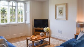 A living room with a TV, a coffee table, and a sofa. - No. 1 The Old School (Puddletown, near Dorchester)