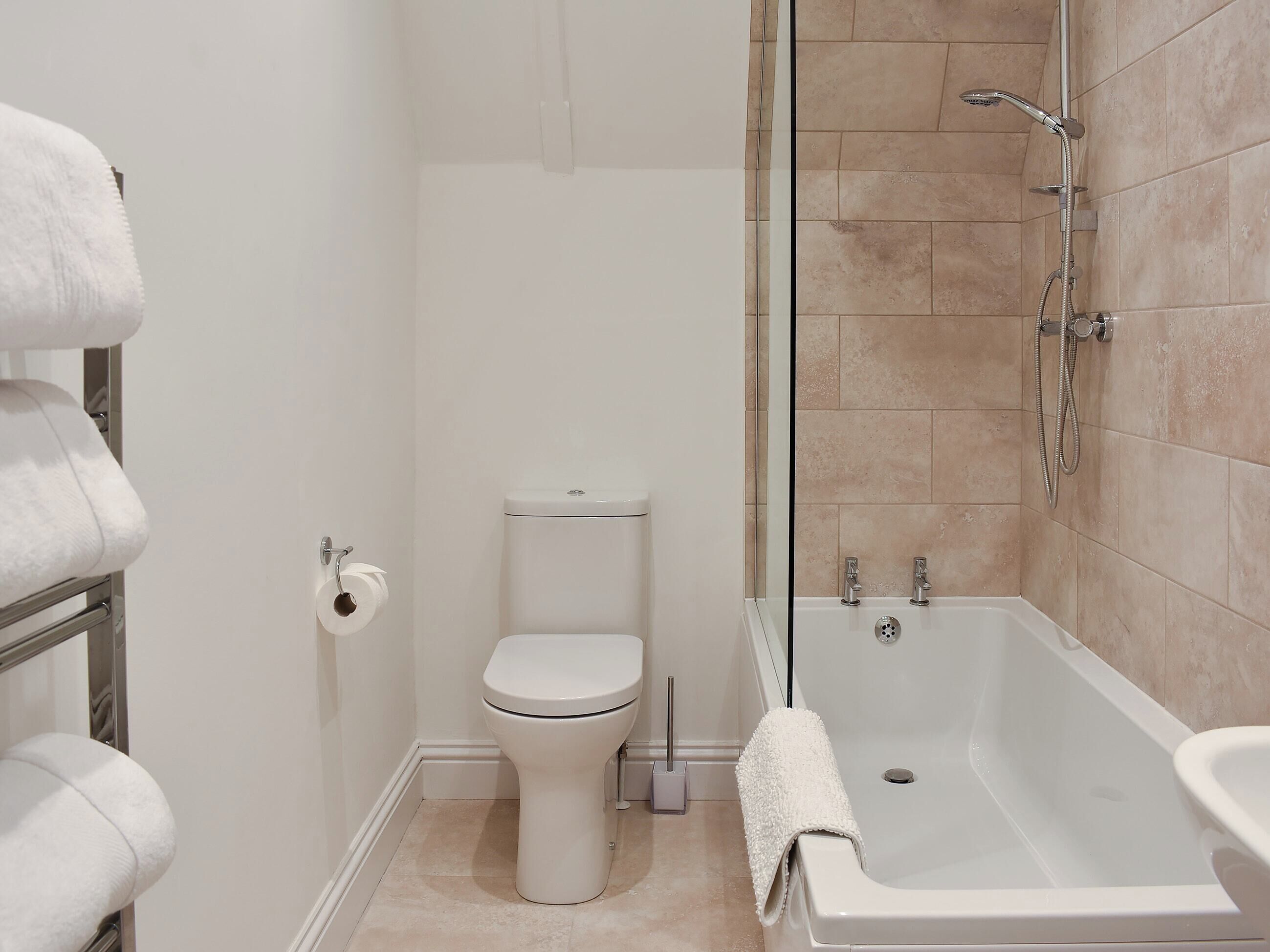 A bathroom with a toilet, a shower with a glass door, and a bathtub.