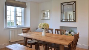 A dining room with a wooden table, chairs, a bench, a potted plant, and a mirror on the wall. - No. 1 The Old School (Puddletown, near Dorchester)
