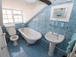 A bathroom with a toilet, a freestanding bathtub, and a pedestal sink. - Buttercup Cottage - UKC2847 (Blakeney, near Holt)