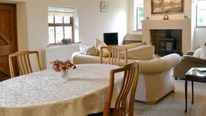 Una sala de estar acogedora con chimenea, una mesa de comedor con sillas y un sofá.