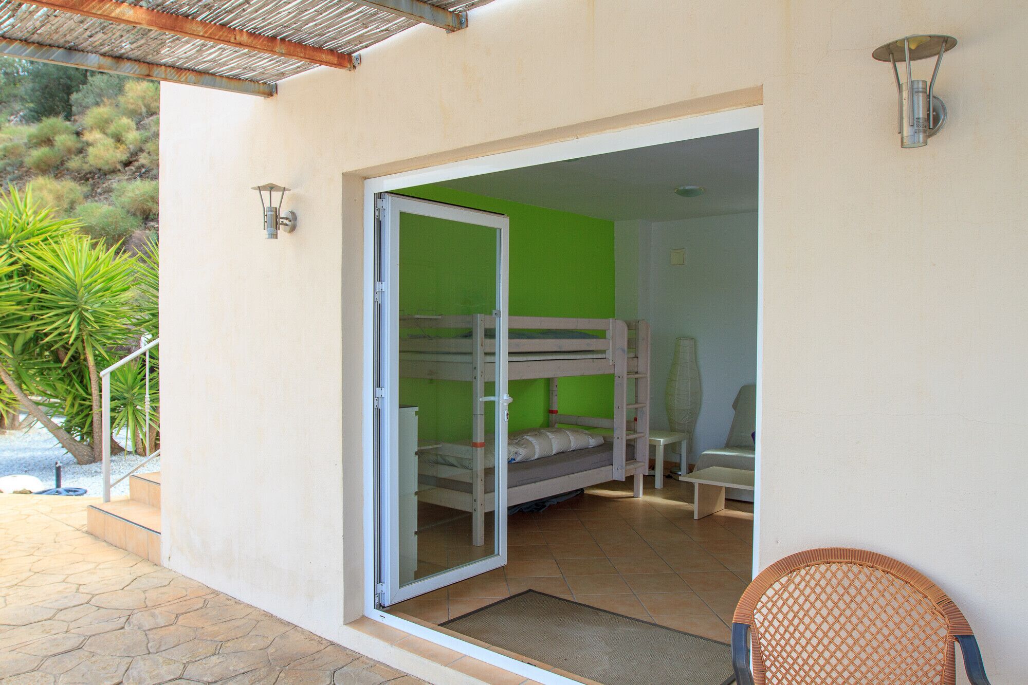 Una habitación con literas, una silla y una mesita.