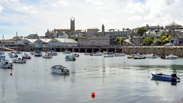 A harbor with boats docked, a church, and a town with buildings in the background. - 3 bedroom accommodation in Penzance (Penzance)