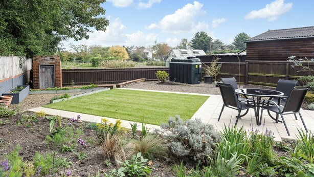 A backyard with a patio, a lawn, and various plants. - 2 bedroom accommodation in Blythburgh, near Southwold (Blythburgh, near Southwold)