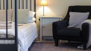 A bedroom with a bed, a nightstand, a lamp, and a chair. - 2 bedroom accommodation in Blythburgh, near Southwold (Blythburgh, near Southwold)
