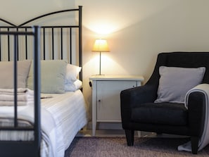 A bedroom with a bed, a nightstand, a lamp, and a chair. - 2 bedroom accommodation in Blythburgh, near Southwold (Blythburgh, near Southwold)