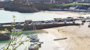 Une ville côtière dotée d’un port de plaisance, d’une plage de sable et d’immeubles résidentiels.