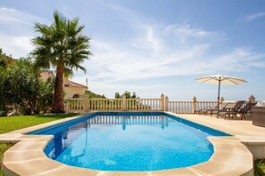 A swimming pool with a curved edge, surrounded by a white fence, and a palm tree to the left. - Casa Bonita | Authentic Andalusian House (Algarrobo)