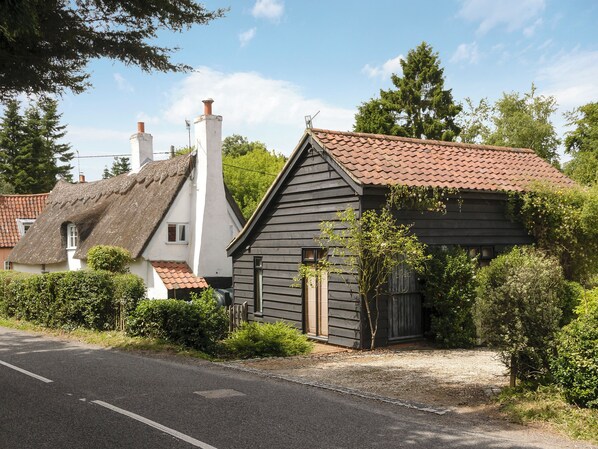 A traditional house with a thatched roof and a wooden structure with a tiled roof.