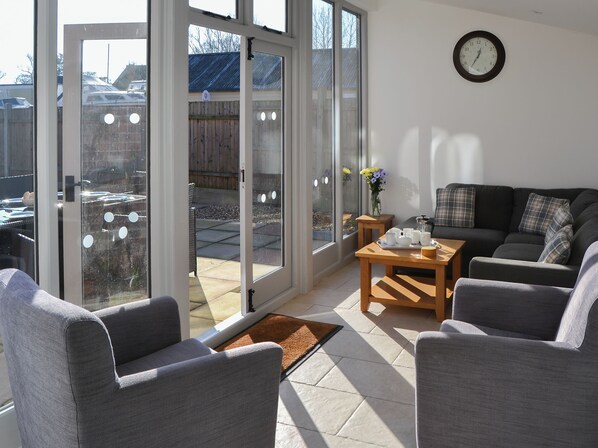 A modern living room with a sofa, chairs, a coffee table, and a dining set.