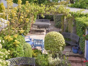 A garden patio with outdoor furniture, a pergola, and various plants. - 2 bedroom accommodation in St. Margarets at Cliffe, near Dover (St. Margarets at Cliffe, near Dover)