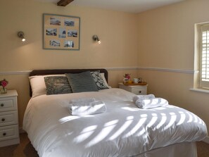 A neatly made bed with white linens and a set of towels, a bedside table with a tray of breakfast items, and a framed picture on the wall. - 2 bedroom accommodation in Rottingdean, near Brighton (Rottingdean, near Brighton)