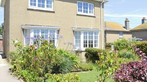 Une maison à deux étages avec un jardin à l’avant.