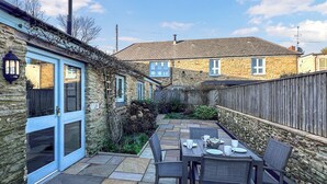 A stone house with a patio area featuring a table set for dining. - 2 bedroom accommodation in East Charleton, near Kingsbridge (East Charleton, near Kingsbridge)