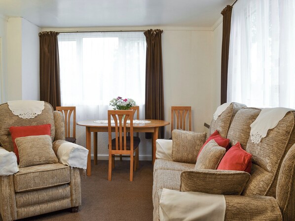 A living room with two sofas, a dining table, and chairs.