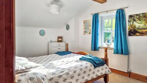 A bedroom with a bed, a dresser, a window with curtains, and a wall with a picture. - 3 bedroom accommodation in Salterforth, near Barnoldswick (Salterforth, near Barnoldswick)