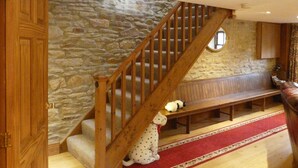 A staircase with a wooden railing leading to a stone wall. A bench is placed under the staircase, and a stuffed toy is sitting on the bench. - 3 bedroom accommodation in Salterforth, near Barnoldswick (Salterforth, near Barnoldswick)