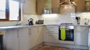 A modern kitchen with stainless steel appliances, a built-in oven, and a window with a view. - 2 bedroom accommodation in Bromlow, near Minsterley (Bromlow, near Minsterley)