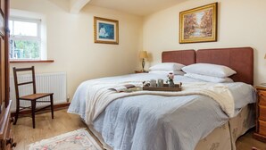 A bedroom with a bed, a chair, a radiator, a window, and two paintings on the wall. - 1 bedroom accommodation in Elsdon (Elsdon)