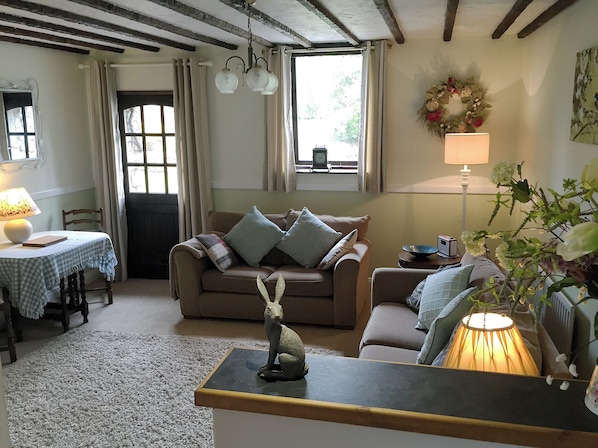 A cozy living room with a sofa, a table with a lamp, and a decorative dog statue.