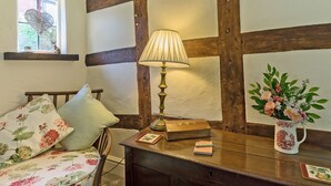 A cozy room with a wooden bench, a table with a lamp, a window with a view, and a floral cushion. - 2 bedroom accommodation in Eckington, near Pershore (Eckington, near Pershore)