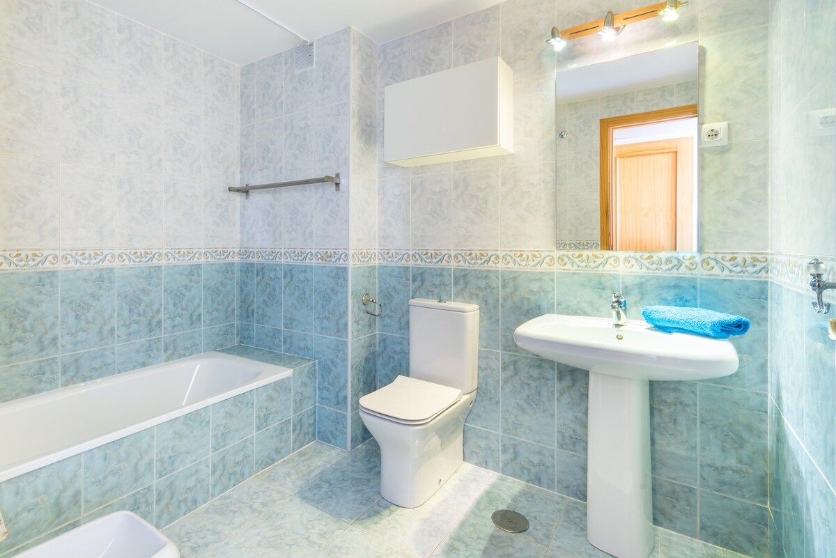 A bathroom with a bathtub, toilet, and sink.