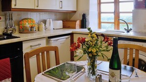 Cuina amb armaris blancs, torradora, tetera i finestra amb vistes.