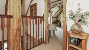 A wooden staircase with a railing leading to a bedroom with a bed and a nightstand. - 2 bedroom accommodation in Kinross, near Perth (Kinross, near Perth)