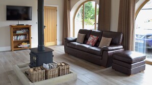A living room with a sofa, a television, a fireplace, and a bookshelf. - 3 bedroom accommodation in Pendleton, near Clitheroe (Pendleton, near Clitheroe)