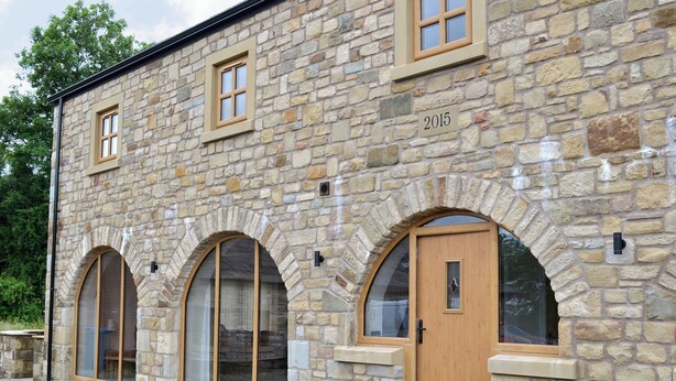 A stone building with arched windows, a wooden door, and a year plaque. - 3 bedroom accommodation in Pendleton, near Clitheroe (Pendleton, near Clitheroe)