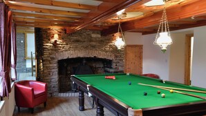 A pool table with balls, a red chair, and a stone fireplace. - The Farmhouse - UKC1339 (Heasley Mill, near South Molton)