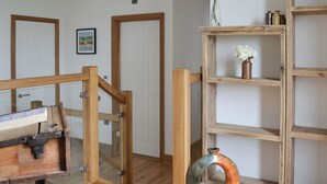 A wooden staircase with glass railings, a rustic shelf with a vase, and a framed picture on the wall. - 4 bedroom accommodation in Winchelsea, near Rye (Winchelsea, near Rye)