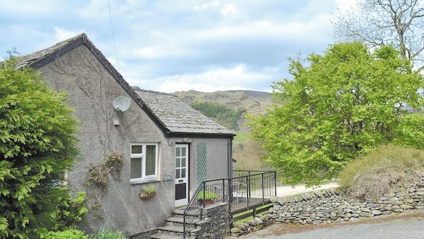 A stone house with a sloped roof, a satellite dish, and a small porch with a stone wall. - 2 bedroom accommodation in Kentmere, near Staveley (Kentmere, near Staveley)