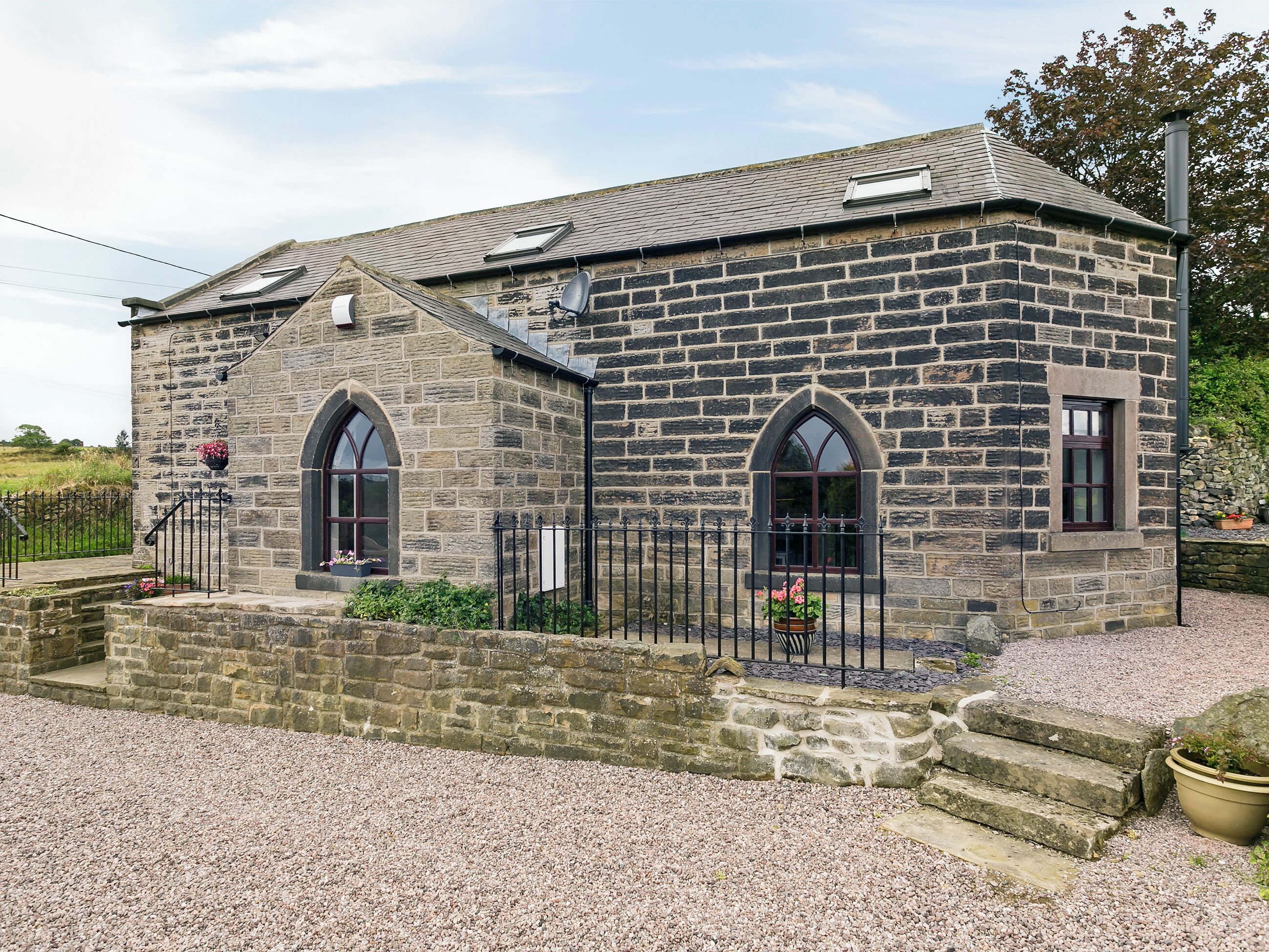 A stone building with two arched windows and a small porch area.
