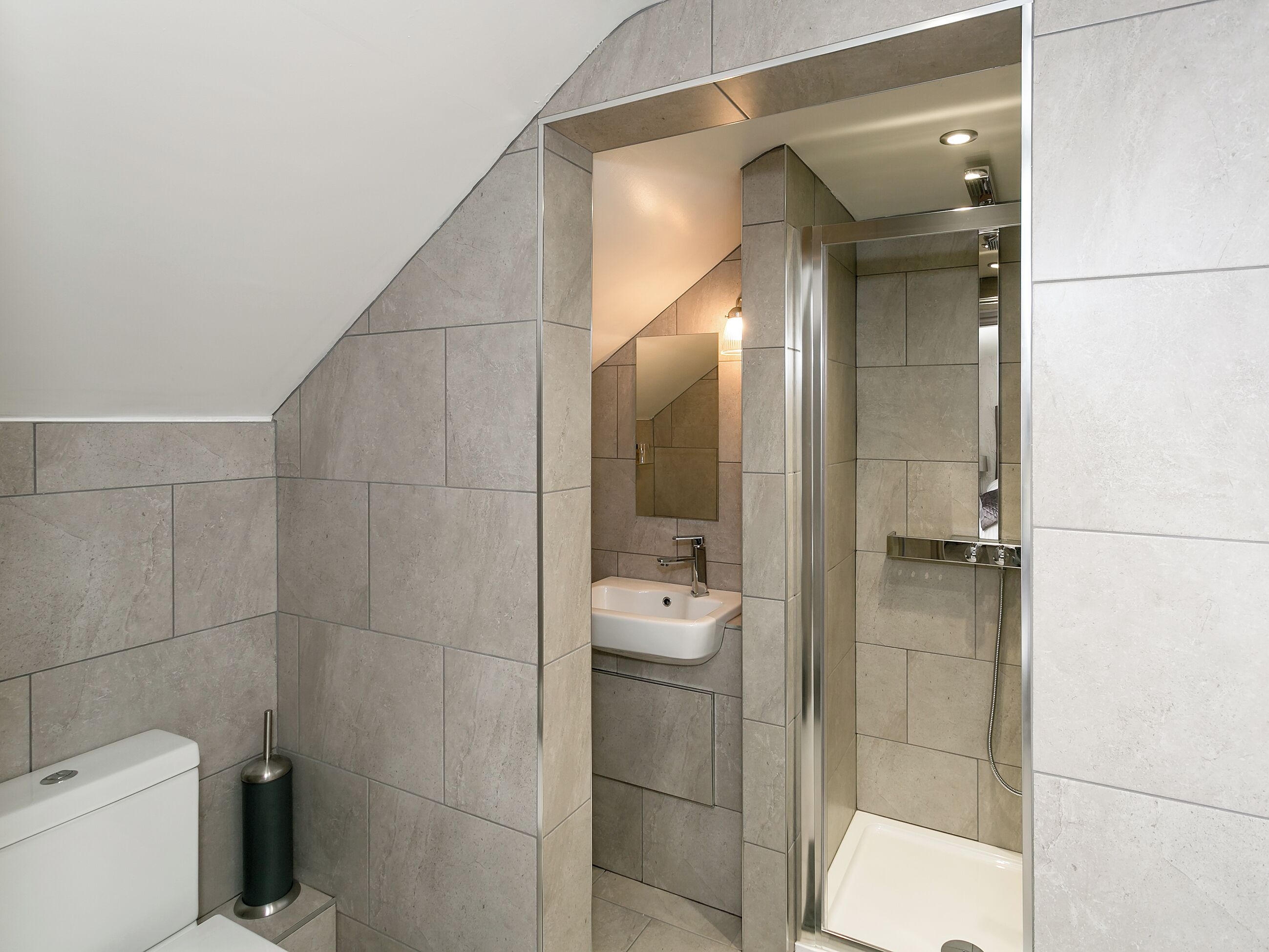 Un baño moderno con ducha, inodoro y lavabo.