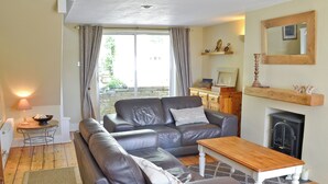 Ein Wohnzimmer mit Sofa, Tisch und Kamin.